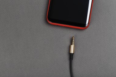 ses kablosu mini jack ve gri bir adam üstünde hareket eden telefon