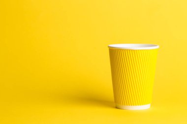 sarı bir arka plan, metin için yer üzerinde tek kullanımlık bir fincan kahve