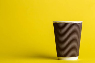 sarı bir arka plan, metin için yer üzerinde tek kullanımlık bir fincan kahve