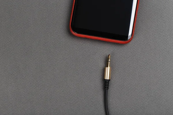 ses kablosu mini jack ve gri bir adam üstünde hareket eden telefon