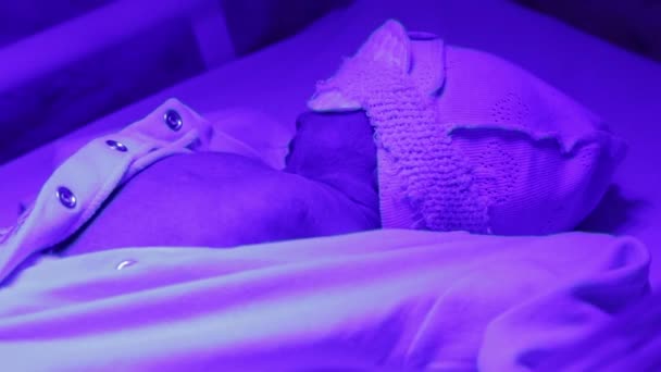 Bebé bajo la lámpara ultravioleta — Vídeo de stock