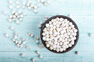 mavi ahşap arka plan üzerinde ham kahverengi nohut. tex için yer