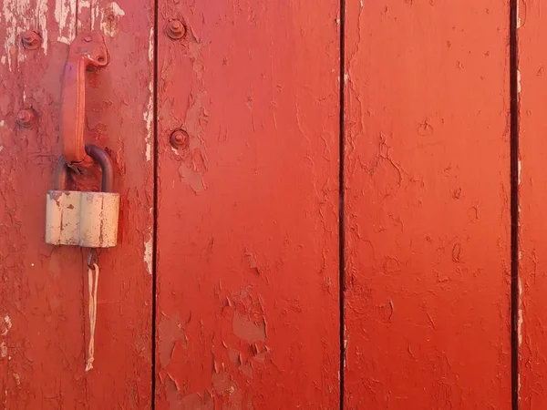 Ahşap kırmızı eski püskü arka plan. açıkça görünür doku pislik ve kırık boya. doo üzerinde kilit olmasının