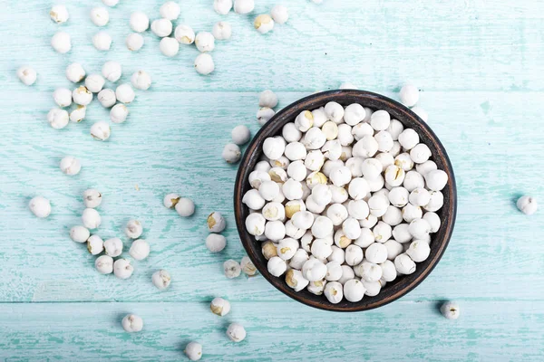 mavi ahşap arka plan üzerinde ham kahverengi nohut. tex için yer