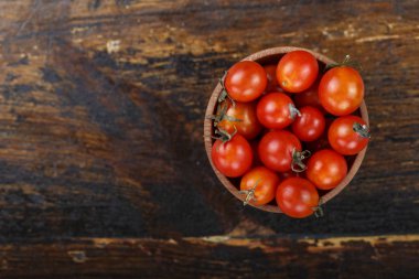 bir tabloda bir ahşap zemin üzerine kiraz domates. yukarıdan görüntüleyin. tex için yer