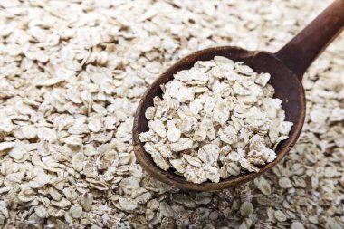 çiğ yulaf ezmesi, bir tahta kaşık yulaf ezmesi ile üzerine dağılmış. adam