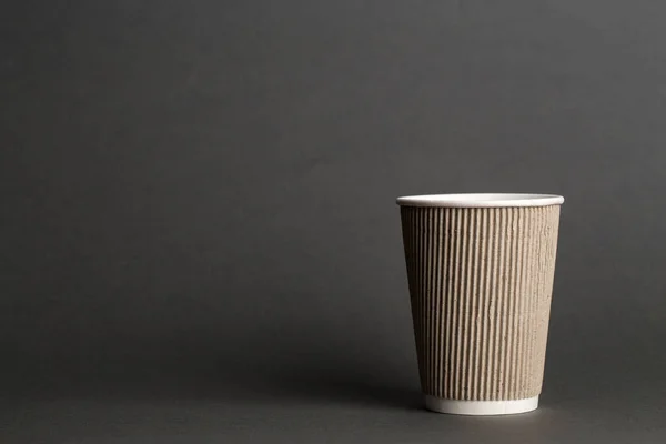 coffee to go in a disposable cup on a black background, place for tex