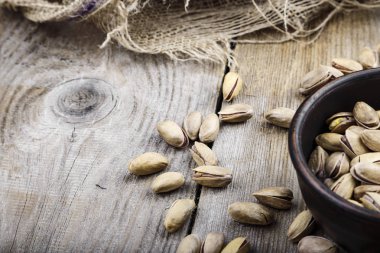 Ahşap arka plan üzerinde bir tabak içinde fıstık fındık. tex için yer