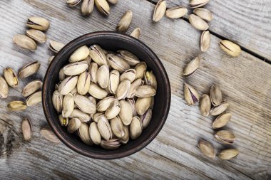 Ahşap arka plan üzerinde bir tabak içinde fıstık fındık. tex için yer