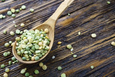 bir tahta kaşık ahşap tabl üzerinde yeşil kuru bezelye