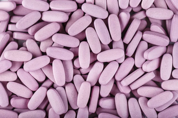 long pink pills as a background. treatment of diseases by medicines. dependence on pills. place for tex