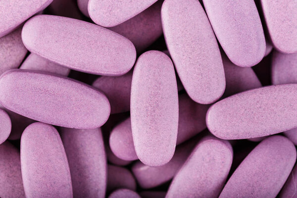 long pink pills as a background. treatment of diseases by medicines. dependence on pills. place for tex