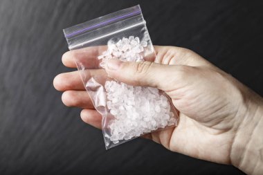 a bag of drugs in the form of white crystals in han clipart