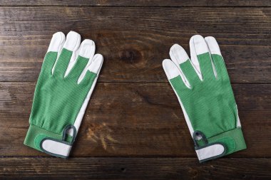 çalışma eldiven beyaz-kahverengi ahşap bir masa üzerinde yeşil temiz. tex için yer
