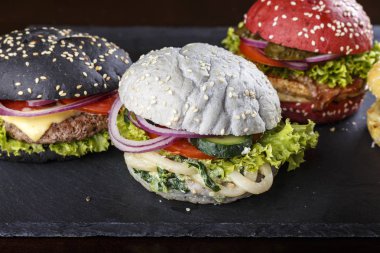 Susam siyah bir arka plan ile çok renkli hamburger. tex için yer