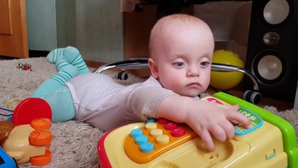 Der Junge liegt auf dem Bauch auf dem Boden — Stockvideo