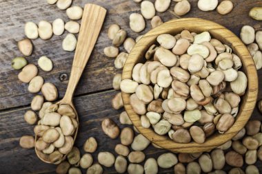 Büyük fasulye bir tahta kaşık ahşap bir masa üzerinde dağılmış