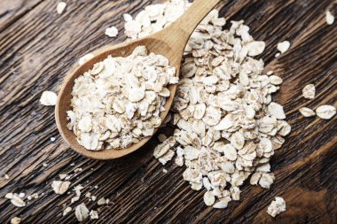 çiğ yulaf ezmesi ahşap bir arka plan üzerinde dağınık. Yulaf ezmesi yemek kahvaltı. tex için yer