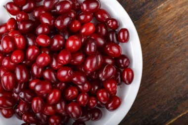 Çilek kızılcık bir plaka üzerinde bir ahşap arka plan vardır. tex için yer