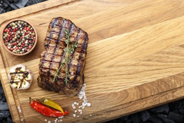 kömürlerin üzerinde bir kesme tahtası üzerinde baharat biftek pişmiş. tex için yer