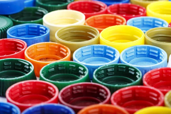 many multicolored plastic bottle caps lined up in rows. spase for tex
