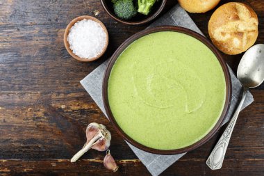 Kremalı brokoli çorbası masaya bir tabak içinde. kaşık ve baharat yanında