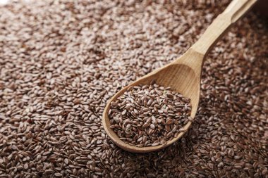 keten tohumu arka plan olarak dağılmış ve içine bir kaşık dökülür. tex için alan