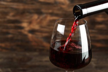 kırmızı şarap bir ahşap arka plan, tex için alan bir cam içine dök