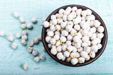 mavi bir eski püskü masaya bir tabak içinde ham baklagiller nohut. tex için alan