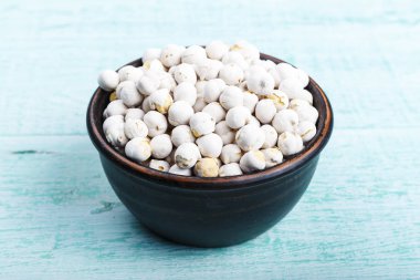 mavi bir eski püskü masaya bir tabak içinde ham baklagiller nohut. tex için alan