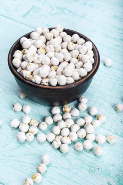 mavi bir eski püskü masaya bir tabak içinde ham baklagiller nohut. tex için alan