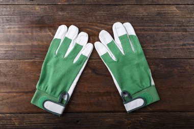 çalışma eldiven beyaz-kahverengi ahşap bir masa üzerinde yeşil temiz. tex için yer