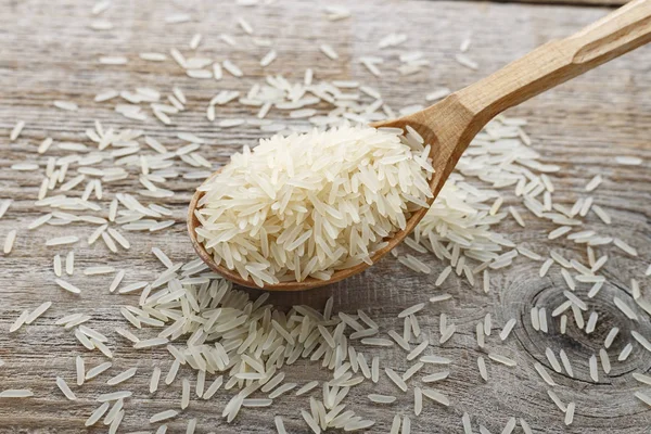 raw long rice in a spoon on a wooden table. traditional asian foo