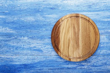 Yuvarlak pizza Yönetim Kurulu eski püskü bir mavi ahşap arka plan üzerinde. tex için alan
