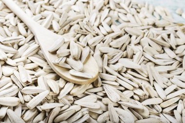 Bir sürü beyaz ayçiçeği tohumu arka plan olarak dağılmışlardır. bir kaşık içinde tohum. tex için alan
