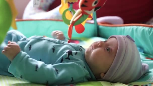 Babyjongen liggend op een ontwikkelende deken — Stockvideo