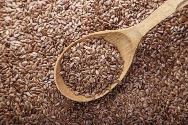 keten tohumu arka plan olarak dağılmış ve içine bir kaşık dökülür. tex için alan