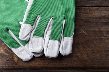 çalışma eldiven beyaz-kahverengi ahşap bir masa üzerinde yeşil temiz. tex için yer