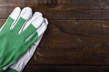 çalışma eldiven beyaz-kahverengi ahşap bir masa üzerinde yeşil temiz. tex için yer