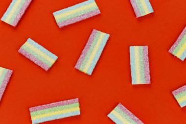 Bir sürü kırmızı bir arka plan üzerinde çok renkli jöle tatlı şekerler. tex için alan