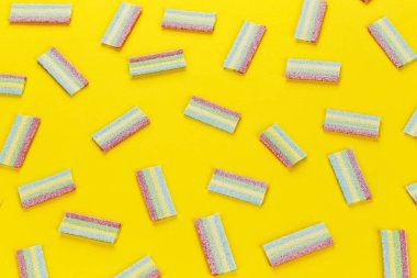 Çok renkli jöle tatlı şekerler sarı bir arka plan üzerinde bir sürü. tex için alan