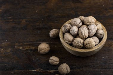 koyu ahşap zemin üzerine kabuklu bütün ceviz. bir ahşap plat