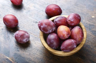 Olgun erik koyu kahverengi ahşap bir masa üzerinde bir ahşap plaka. rustik tarzı