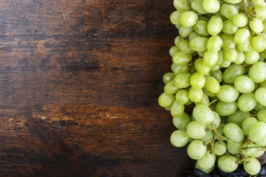 kahverengi ahşap zemin üzerine yeşil üzüm taze demet. tex için alan