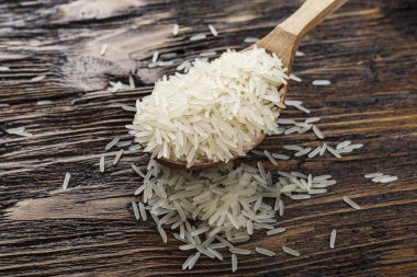 ahşap bir zemin üzerine bir kaşık çiğ pirinç. metin için yer. Geleneksel Asya foo