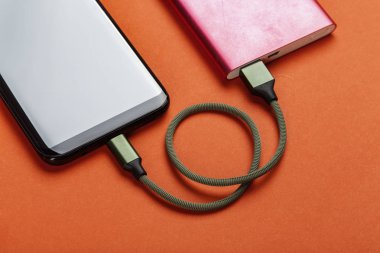 Renk arka plan üzerinde güç banka ile şarj Smartphone