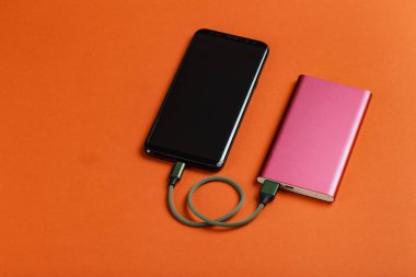 Renk arka plan üzerinde güç banka ile şarj Smartphone
