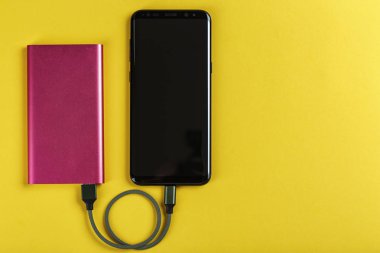 Renk arka plan üzerinde güç banka ile şarj Smartphone
