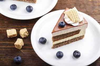 Kahverengi ahşap arka plan üzerinde yaban mersini ile peynir pasta dilimi