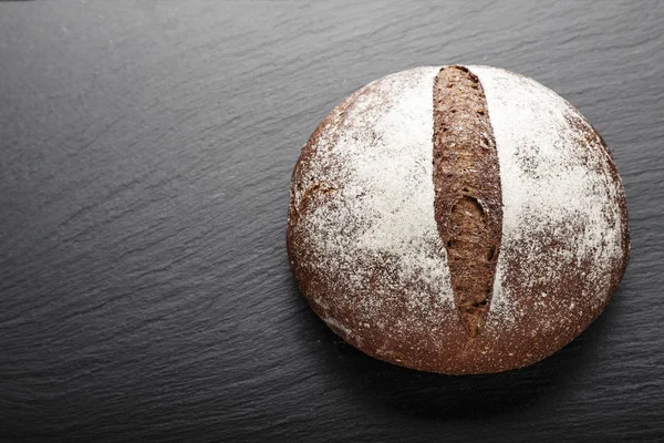 black round homemade bread on a black background. space for tex